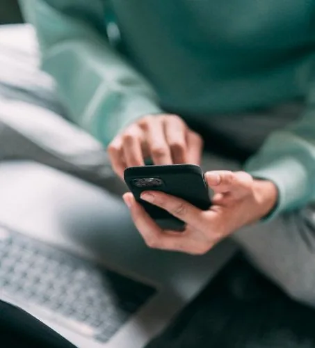 Mani che usano telefono con computer